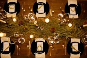 An image of a Christmas Day table setting - a birdseye view of plates, cups, greenery and cutlery.